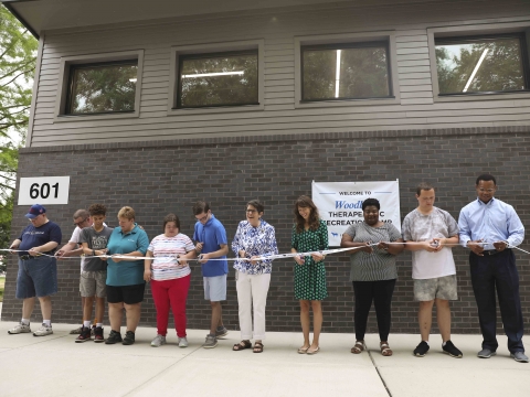 Mayor Linda Gorton, other employees and TR campers cut a ribbon in front of a new brick building