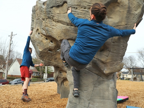 Two people climb new climbing boulders at Northeastern Park in Lexington