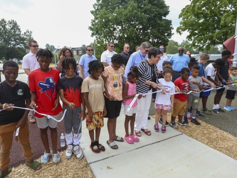 school aged kids join Mayor Linda Gorton for a ribbon cutting on the new playground