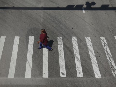 a photo taken from above of a woman walking in a crosswalk