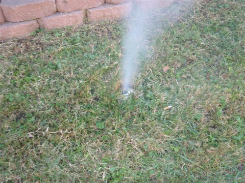 a photo of white smoke coming out of the ground during smoke testing