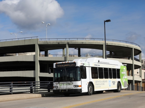 A Lextran bus on a sunny day driving across a bridge in downtown Lexington