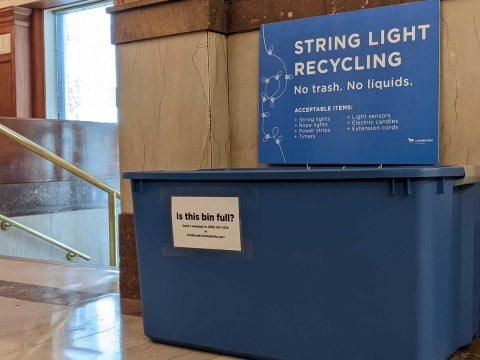 a blue bin with a blue sign that says "holiday lights collection" 